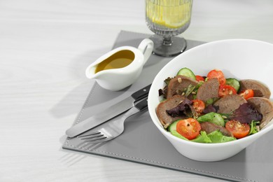 Photo of Delicious salad with beef tongue and vegetables served on white wooden table. Space for text