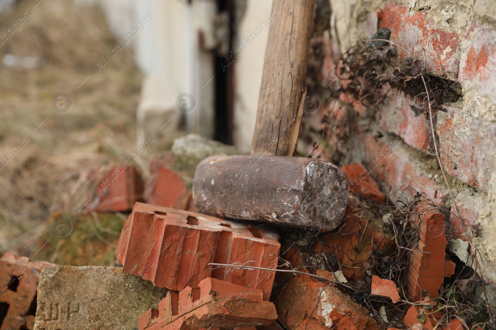 Photo of Sledgehammer near brick wall outdoors, closeup. Space for text