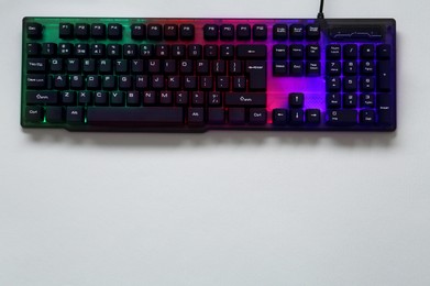 Photo of Modern RGB keyboard on grey background, top view. Space for text