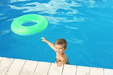 Little child with inflatable ring in outdoor swimming pool. Dangerous situation