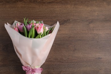 Bouquet of beautiful tulips on wooden table, top view. Space for text