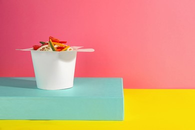 Box of vegetarian wok noodles on color background. Space for text