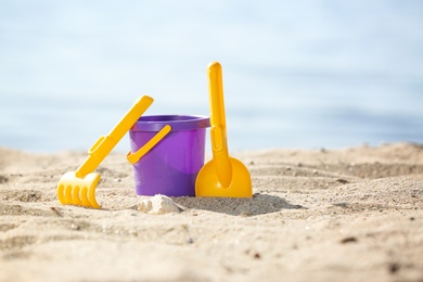 Photo of Children toys on sand near sea. Beach object