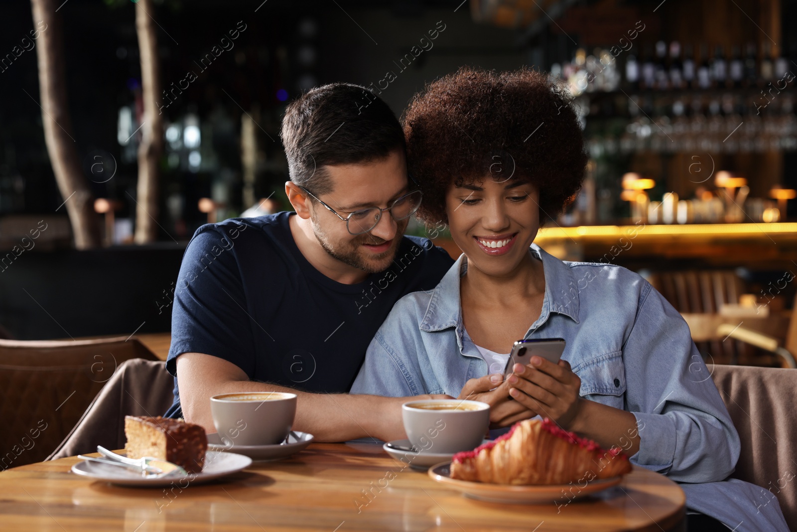 Photo of International dating. Lovely couple spending time together in cafe