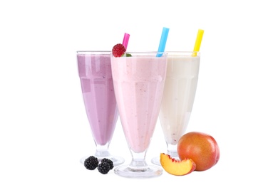 Photo of Different fresh tasty milk shakes in glasses with ingredients on white background