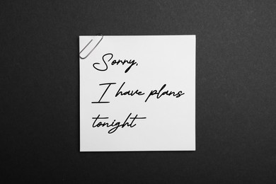 Image of White note with phrase Sorry, I Have Plans Tonight on black background, top view