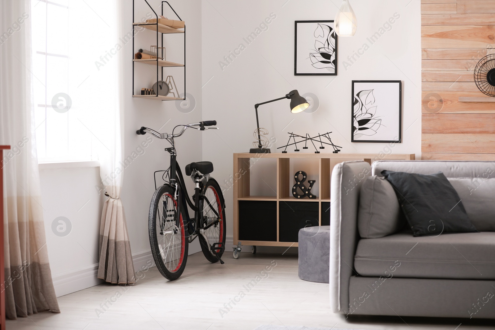 Photo of Light living room interior with comfortable sofa and bicycle