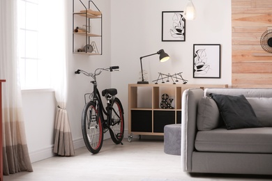 Photo of Light living room interior with comfortable sofa and bicycle