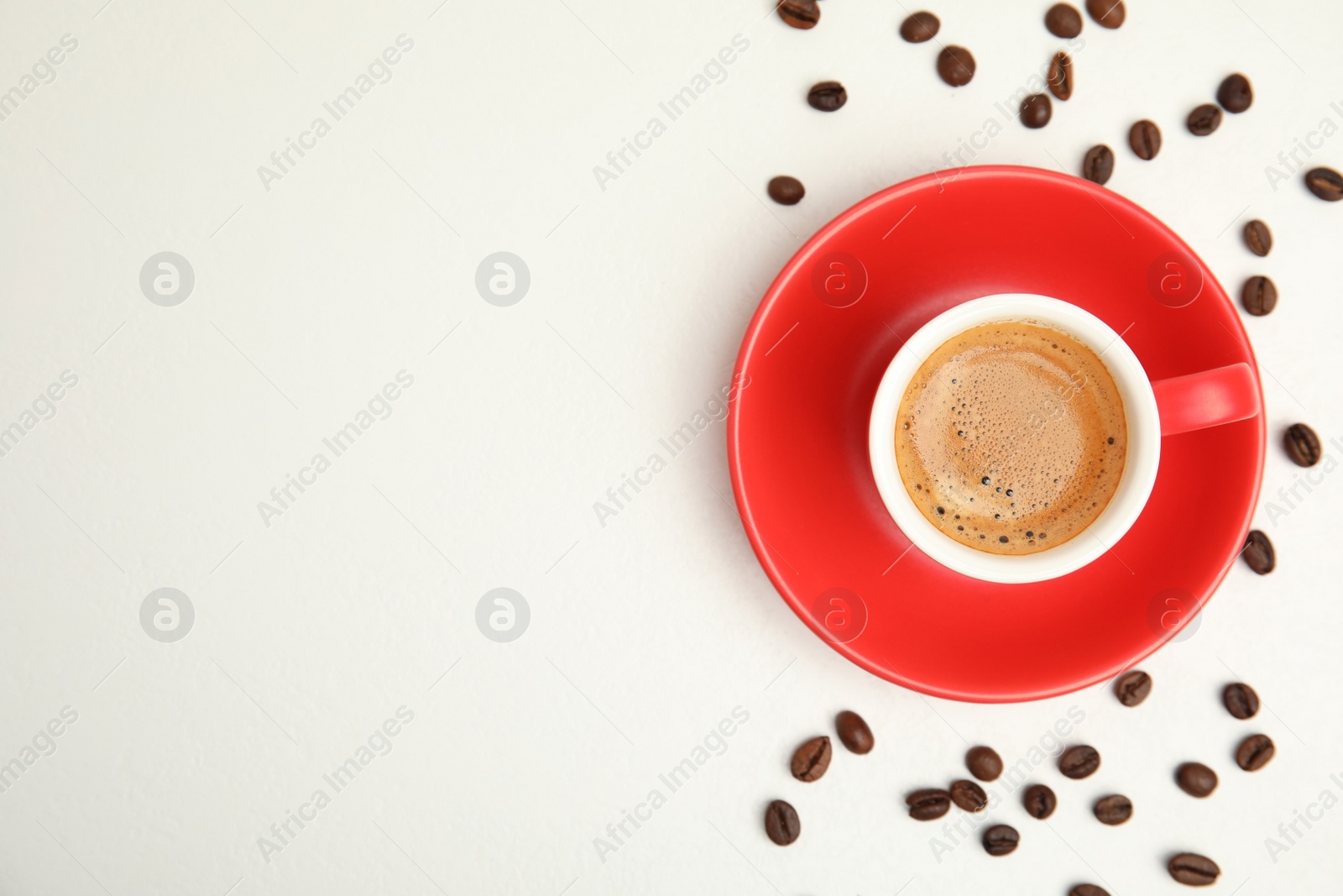 Photo of Cup of tasty coffee and beans isolated on white, top view. Space for text