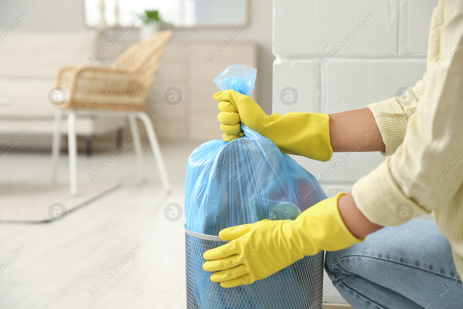 Photo of Woman taking garbage bag out of bin at home, closeup. Space for text