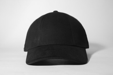 Photo of Stylish black baseball cap on white background