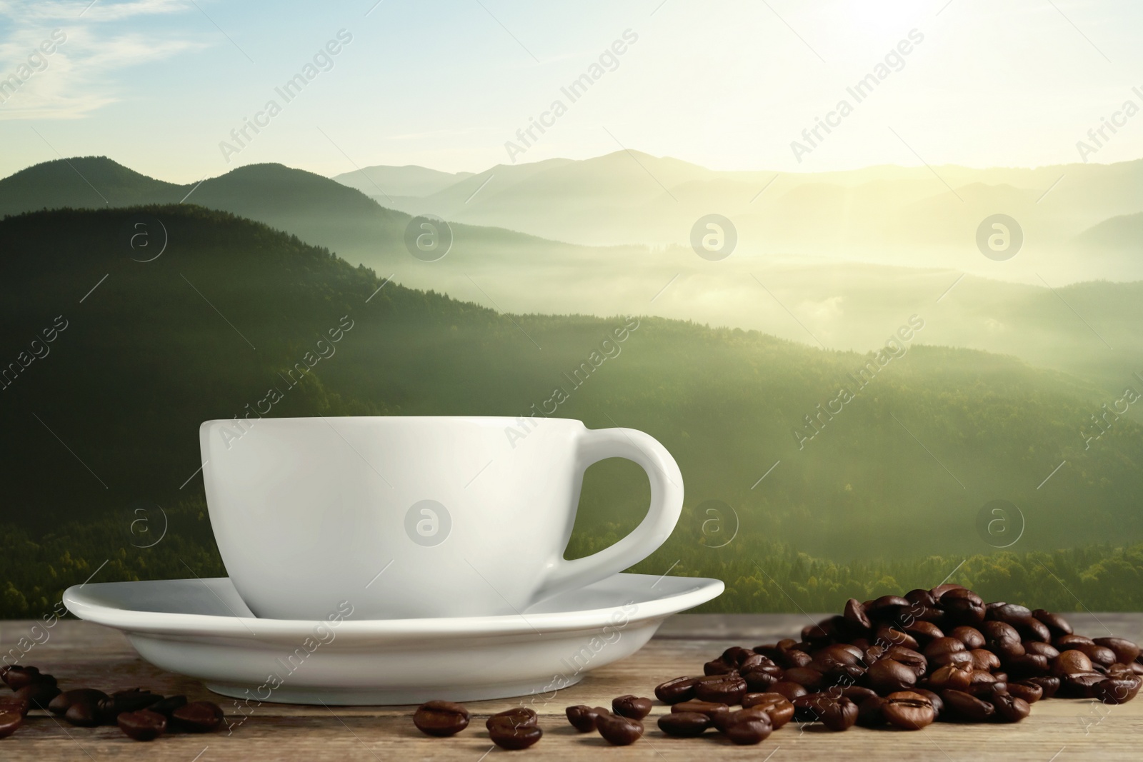 Image of Cup of aromatic hot coffee on wooden table and beautiful view of mountain landscape