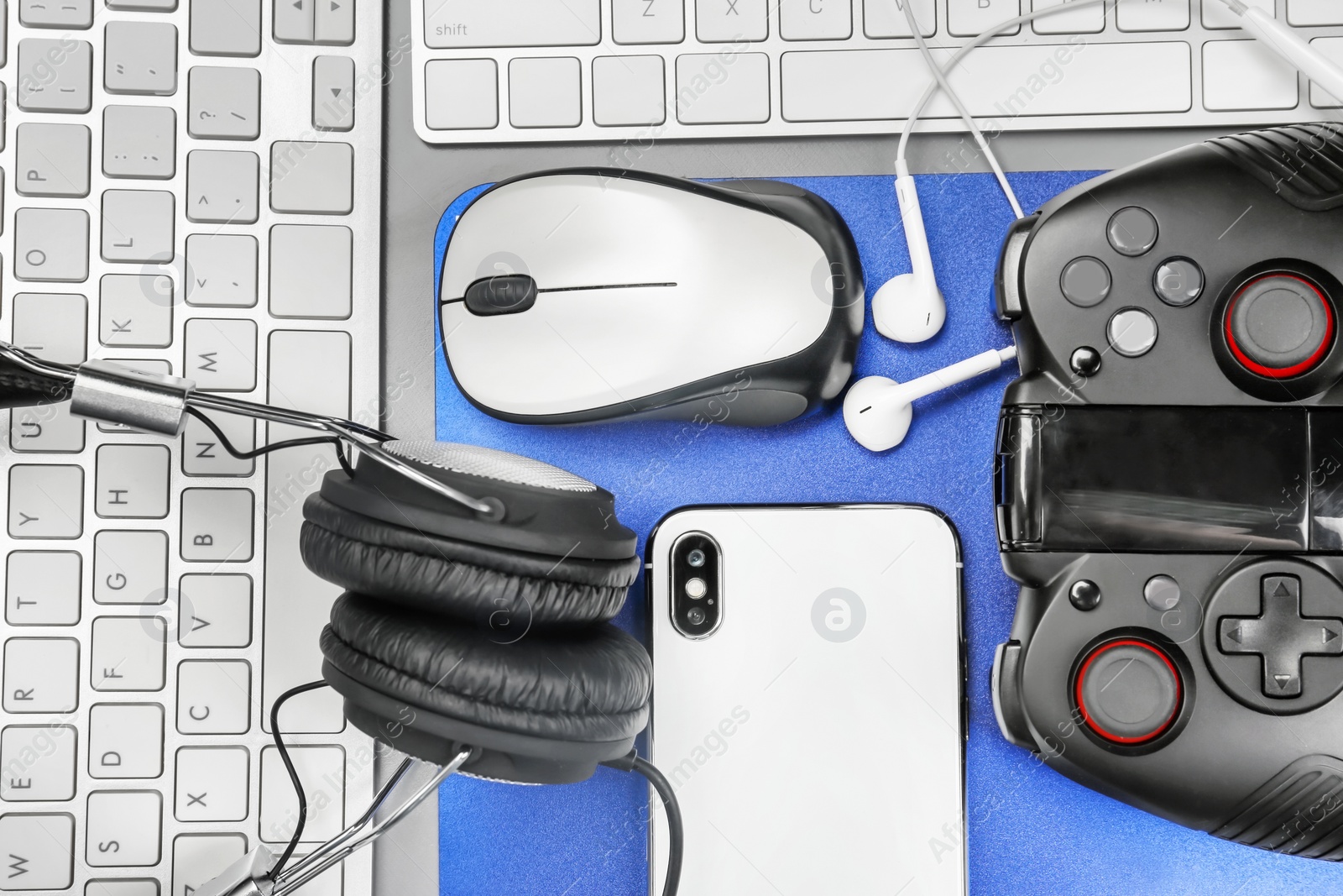 Photo of Flat lay composition with computer mouse, smartphone and gaming gear on table