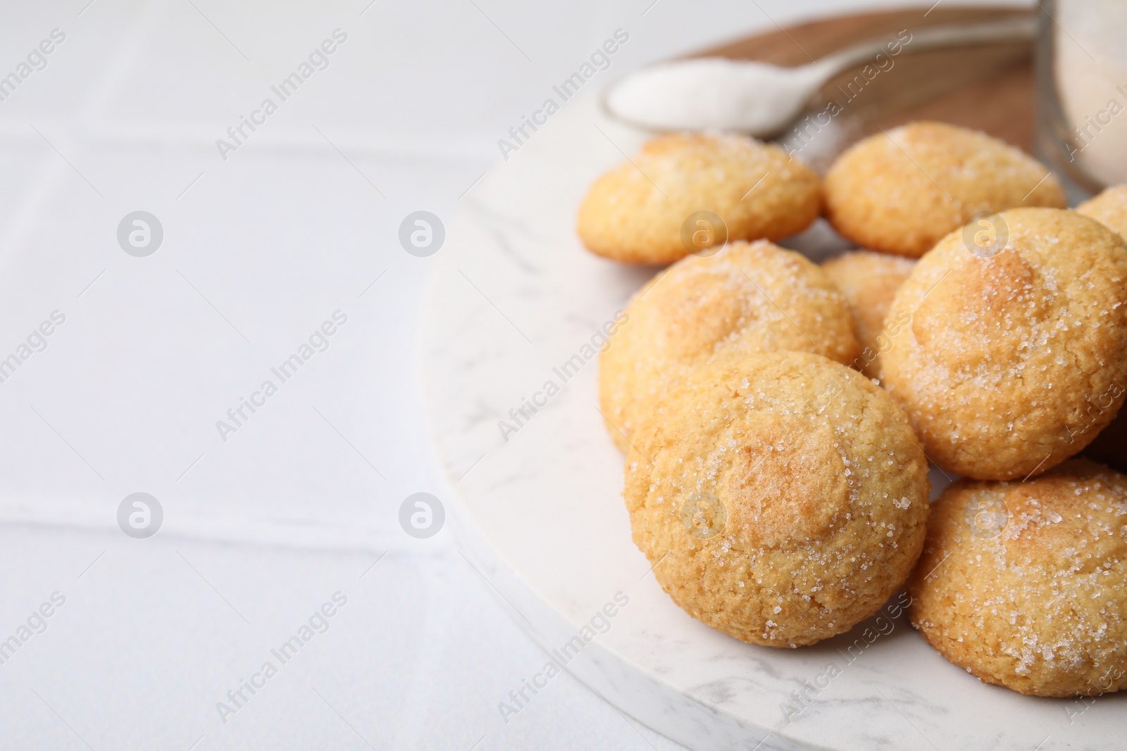 Photo of Tasty sweet sugar cookies on white tiled table, closeup. Space for text