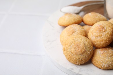 Photo of Tasty sweet sugar cookies on white tiled table, closeup. Space for text