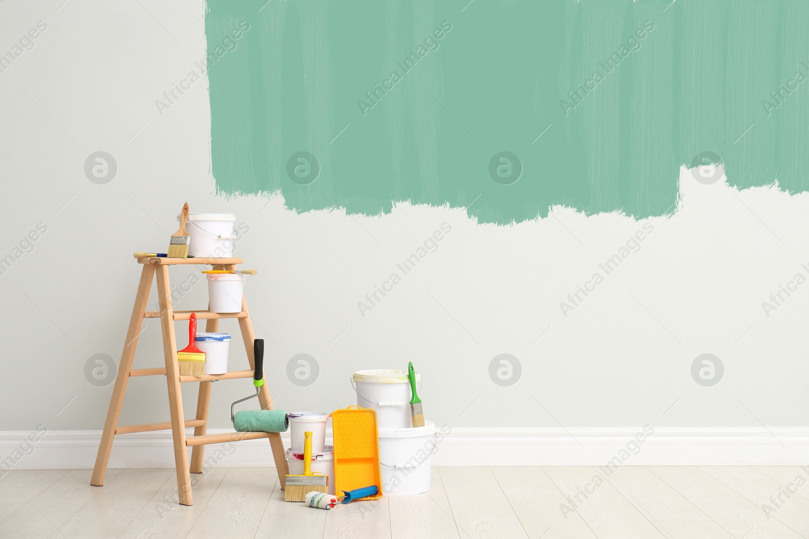 Image of Decorator's kit of tools and paints near wall indoors