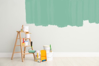 Decorator's kit of tools and paints near wall indoors