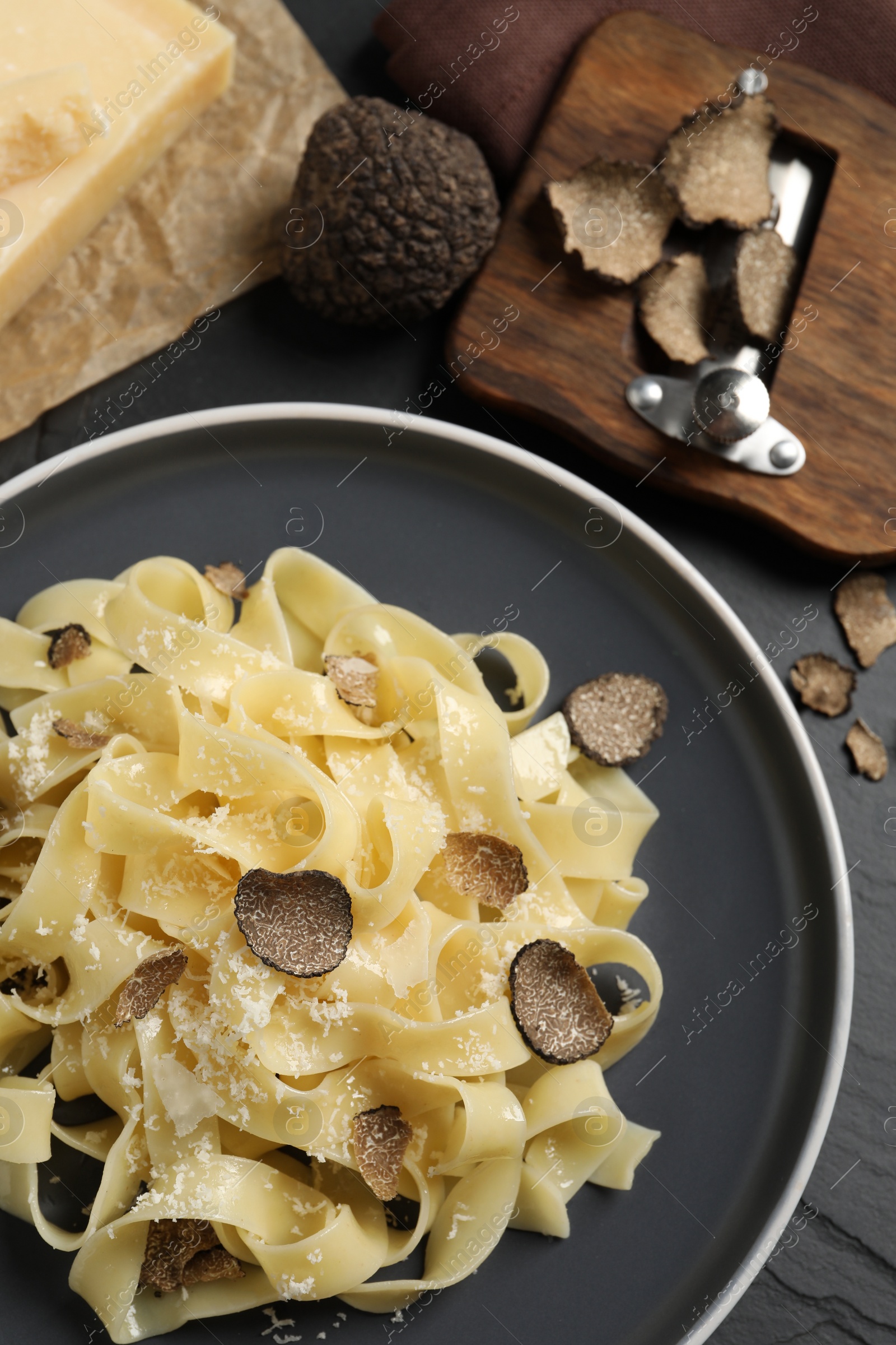 Photo of Tasty tagliatelle with truffle on black table, flat lay