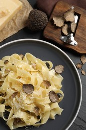 Photo of Tasty tagliatelle with truffle on black table, flat lay