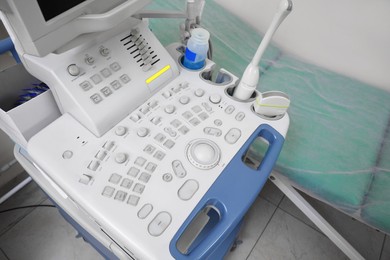Photo of Ultrasound control panel and examination table in hospital, closeup
