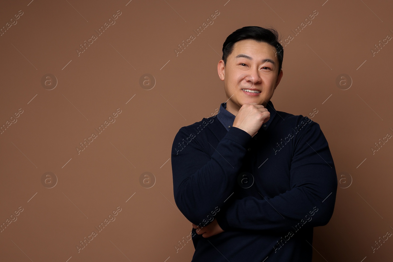 Photo of Portrait of happy man on brown background. Space for text