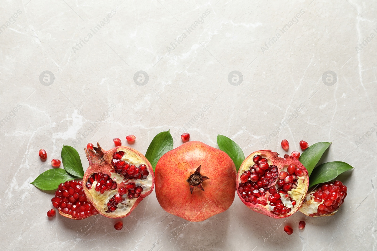 Photo of Flat lay composition with ripe pomegranates and space for text on light background