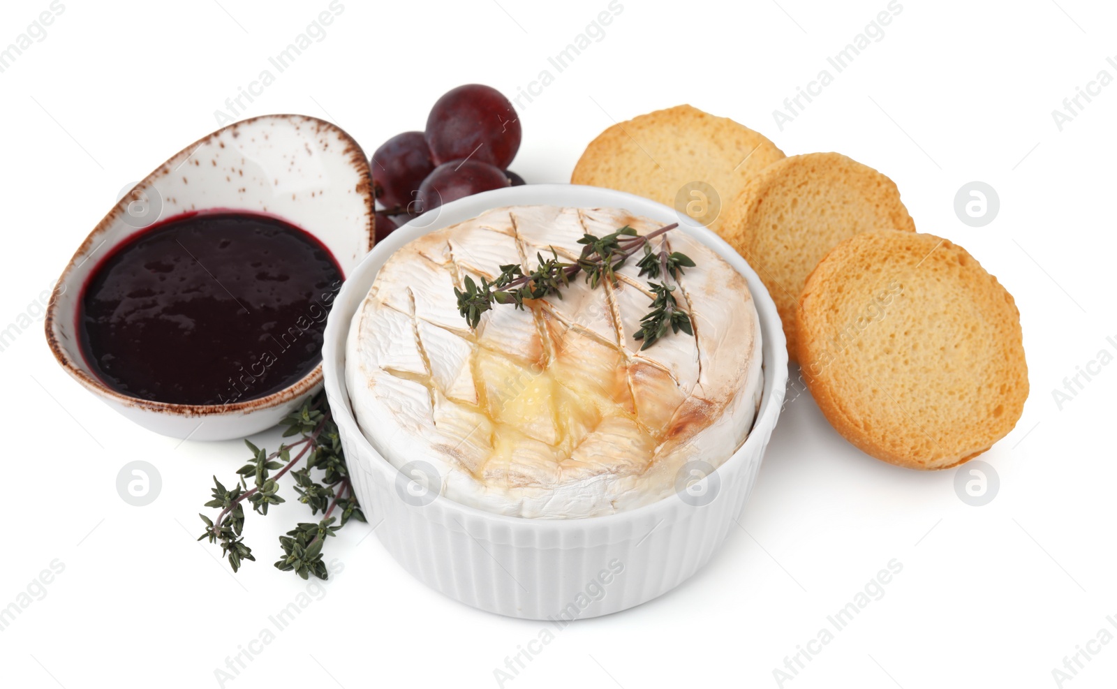 Photo of Tasty baked camembert, croutons, grapes and jam isolated on white