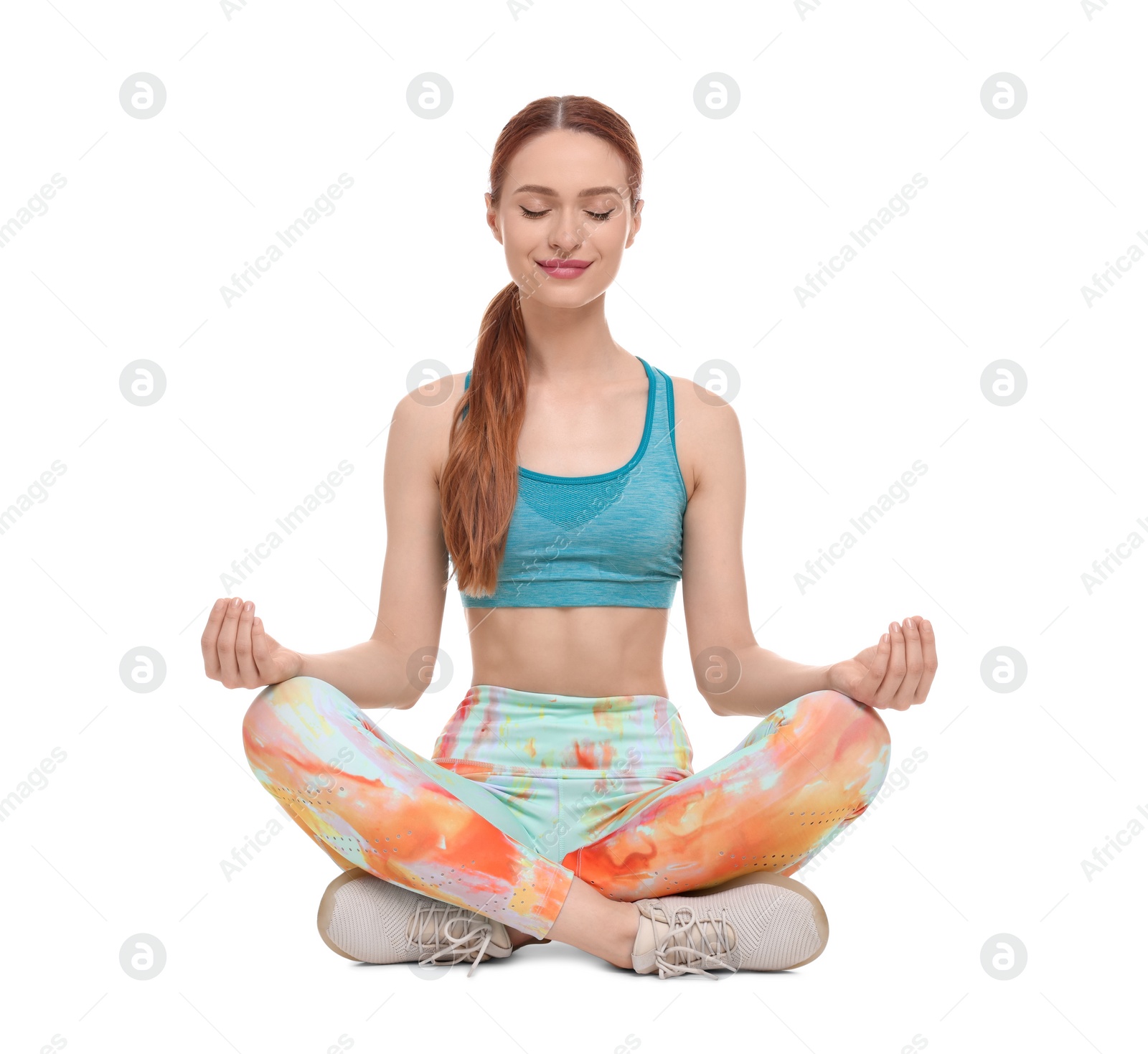 Photo of Young woman in sportswear meditating on white background