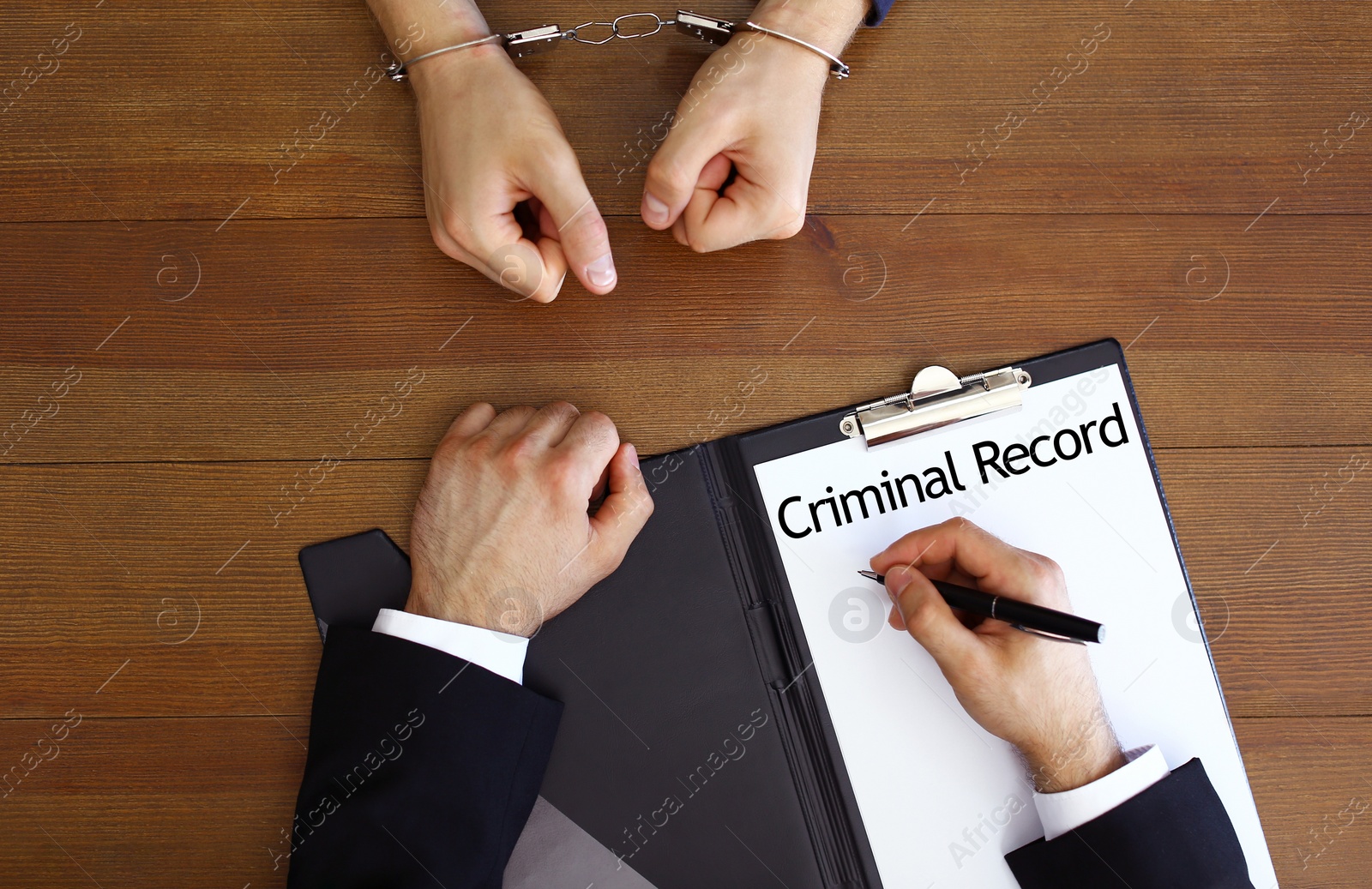 Image of Police officer examining criminal record at desk, top view
