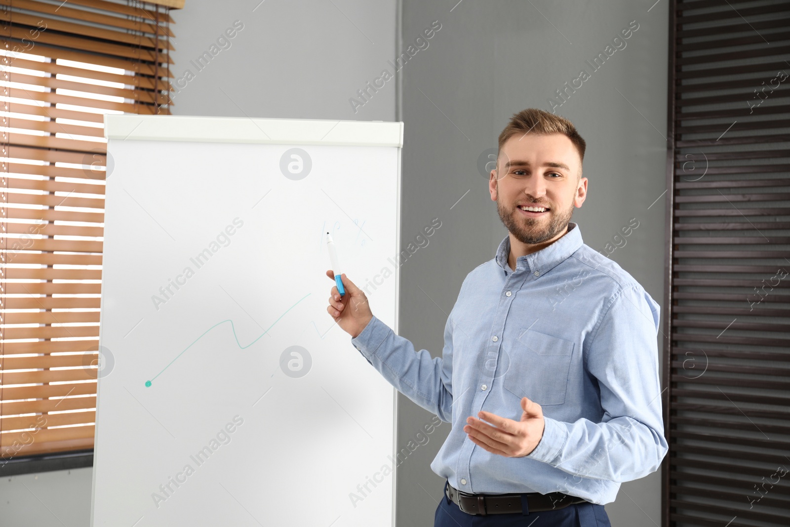 Photo of Professional business trainer near flip chart in office