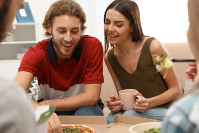Young people having lunch together at home. Food delivery