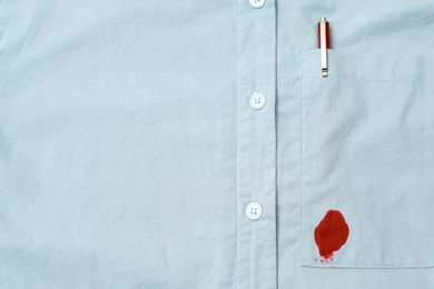 Photo of Shirt with stain of red ink and pen in pocket, top view