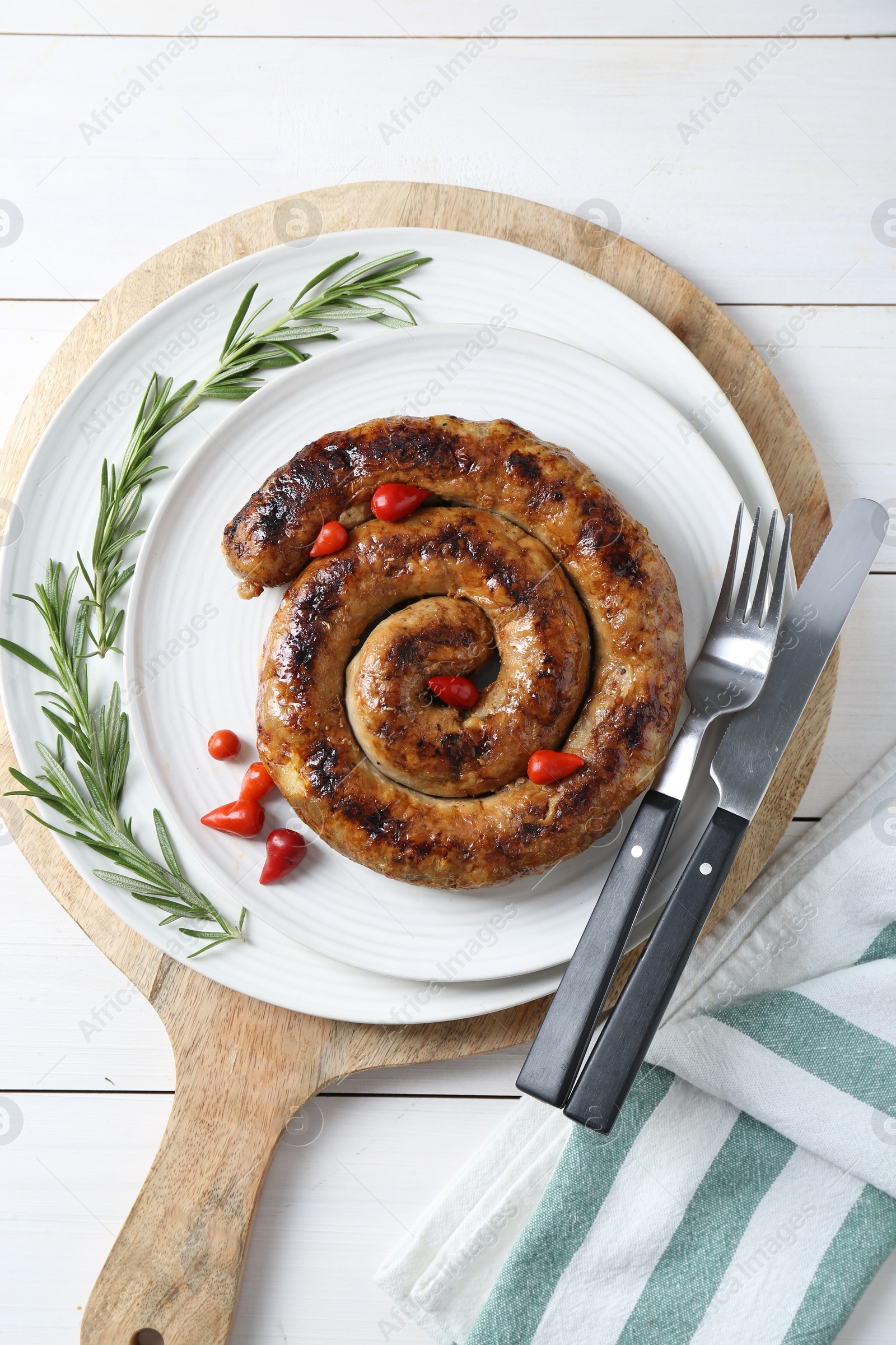Photo of Tasty homemade sausages served on white wooden table, flat lay
