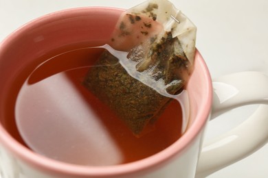 Tea bag in cup on white background, closeup