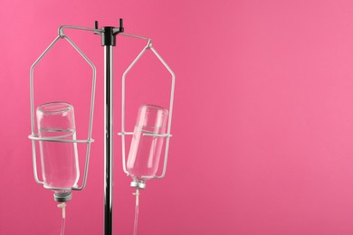 IV infusion set on pink background. Space for text