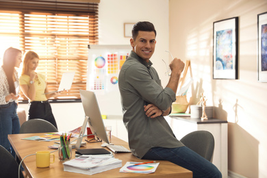 Photo of Portrait of happy male designer in office