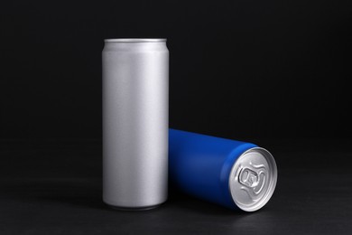 Energy drinks in cans on black wooden table
