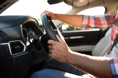 Photo of Man at steering wheel of car, closeup. Driving school