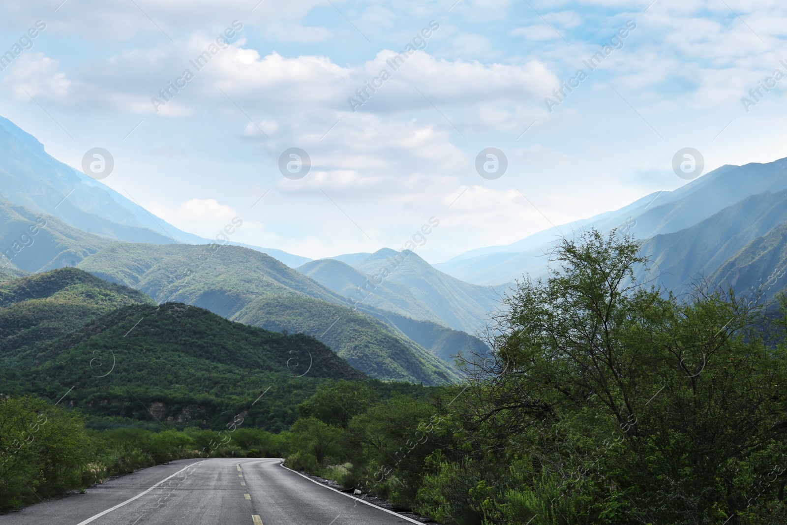 Photo of Beautiful view of empty asphalt highway near mountains outdoors. Road trip