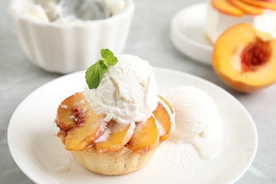 Delicious peach dessert with ice cream on table, closeup