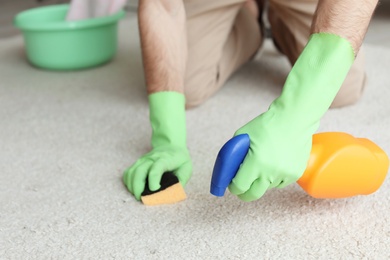 Photo of Man cleaning carpet at home