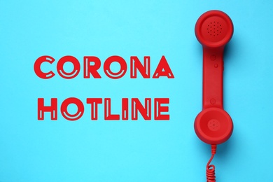 Image of Covid-19 Hotline. Red handset and text on blue background, top view