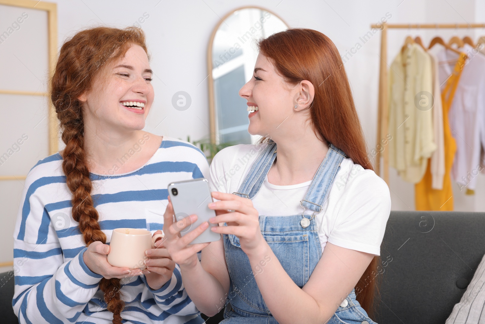 Photo of Beautiful young sisters spending time together at home