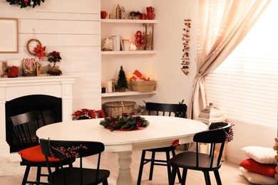 Photo of Cozy dining room interior with Christmas decor and fireplace