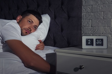 Photo of Man suffering from insomnia in bed at home