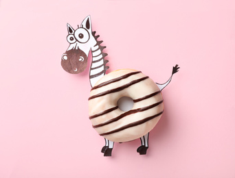 Photo of Funny zebra made with donut and piece of paper on pink background, top view
