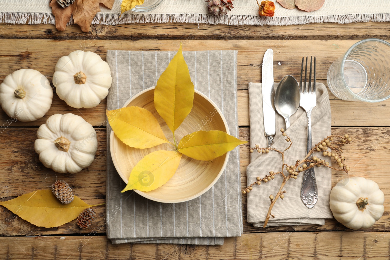 Photo of Seasonal table setting with pumpkins and other autumn decor on wooden background, flat lay