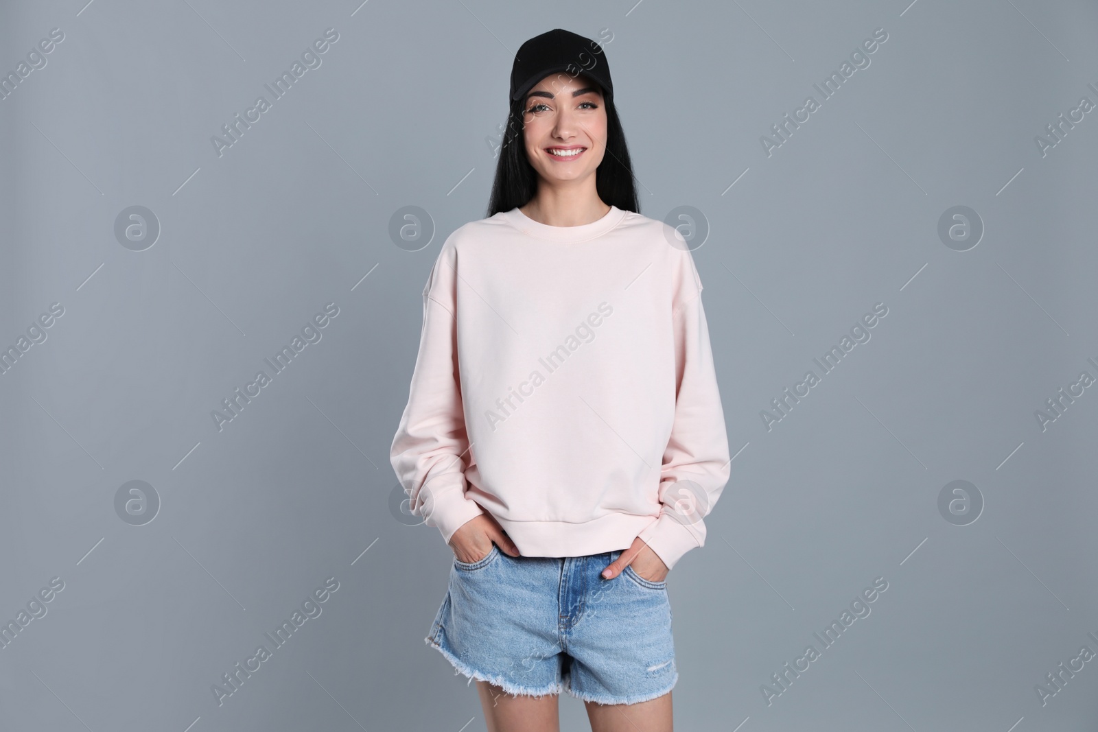 Photo of Portrait of young woman in sweater on grey background. Mock up for design