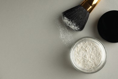 Photo of Rice loose face powder and makeup brush on light grey background, flat lay. Space for text