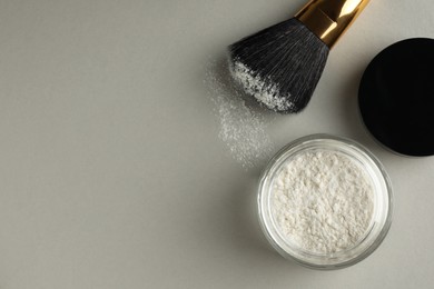 Rice loose face powder and makeup brush on light grey background, flat lay. Space for text